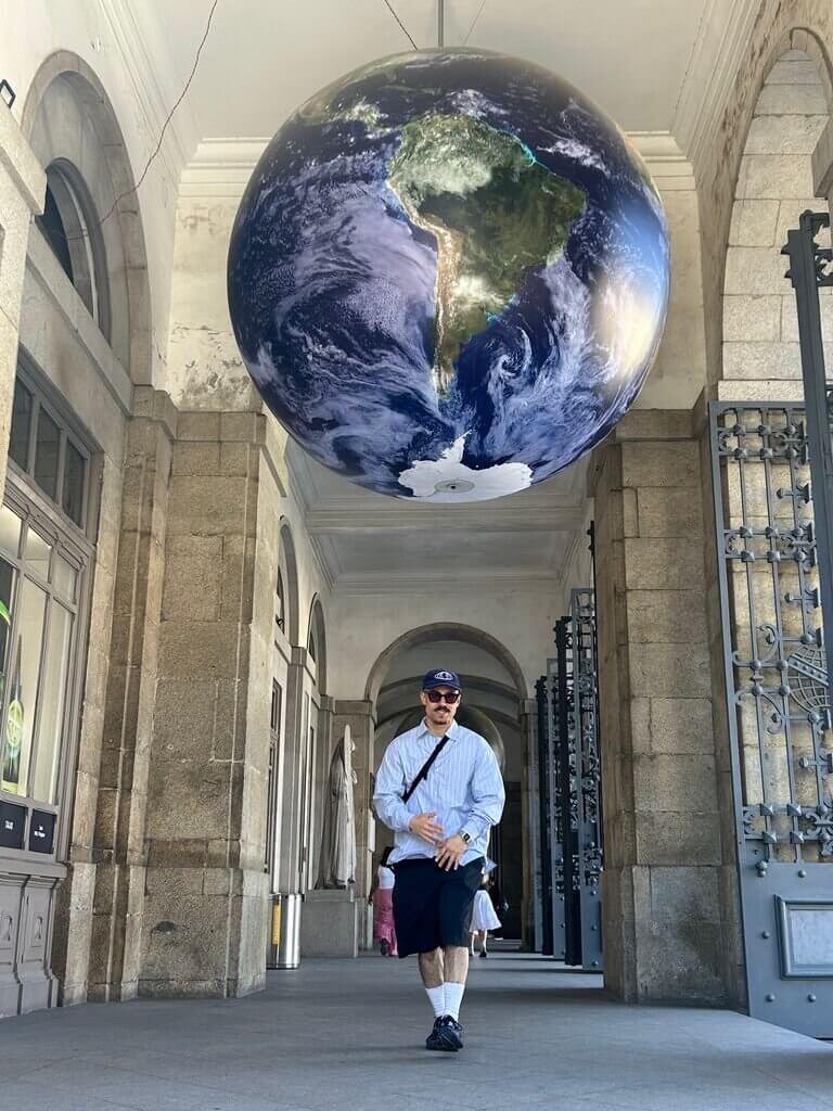 A dancer beneath a suspended globe: Porto 2025.