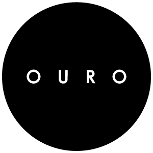OURO Collective old logo: white spaced capitals in a black circle